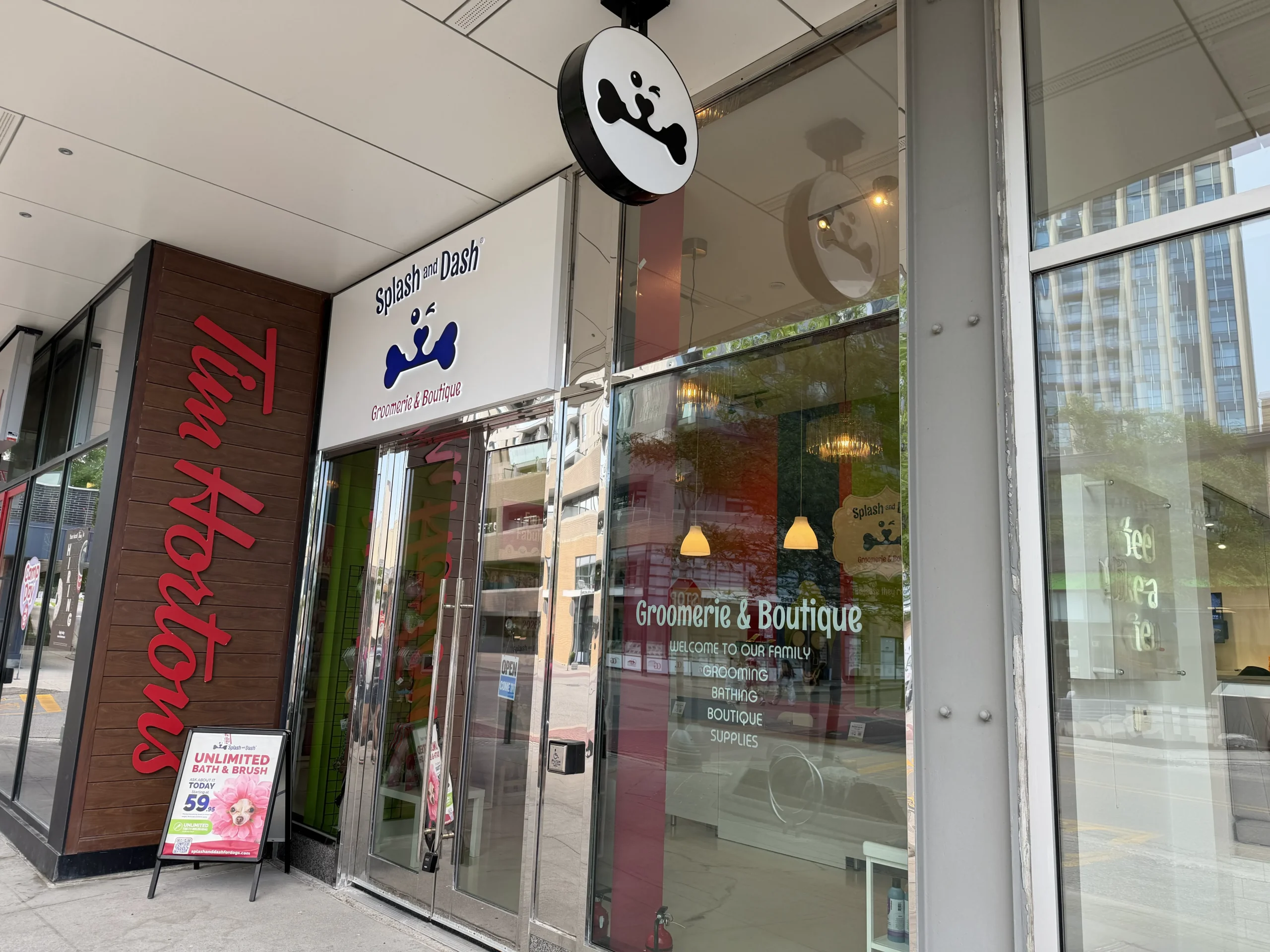 Exterior entrance of Splash and Dash Groomerie & Boutique with storefront signage and glass doors.