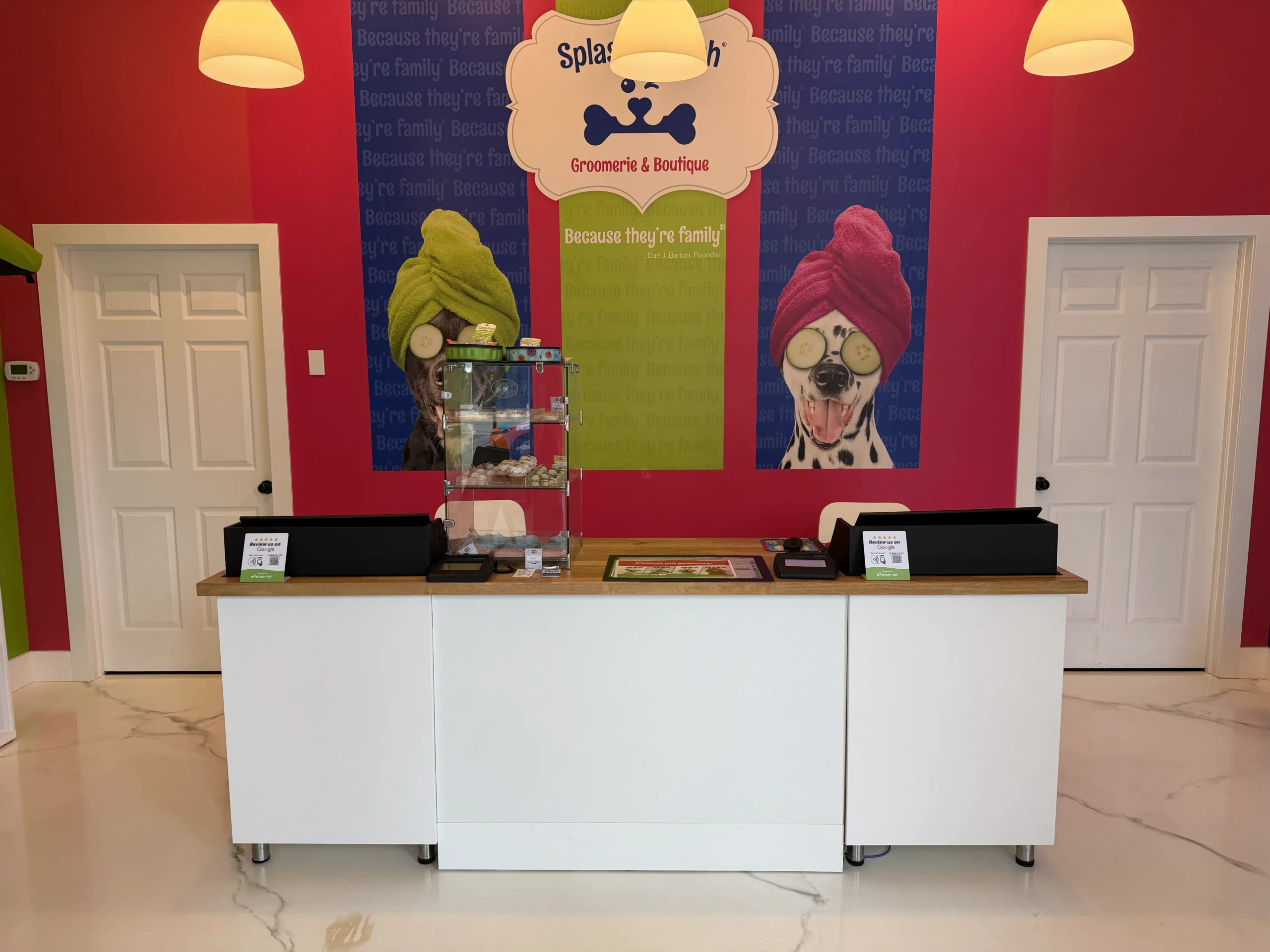 Reception desk inside Splash and Dash Groomerie & Boutique with colorful décor and branded wall displays.
